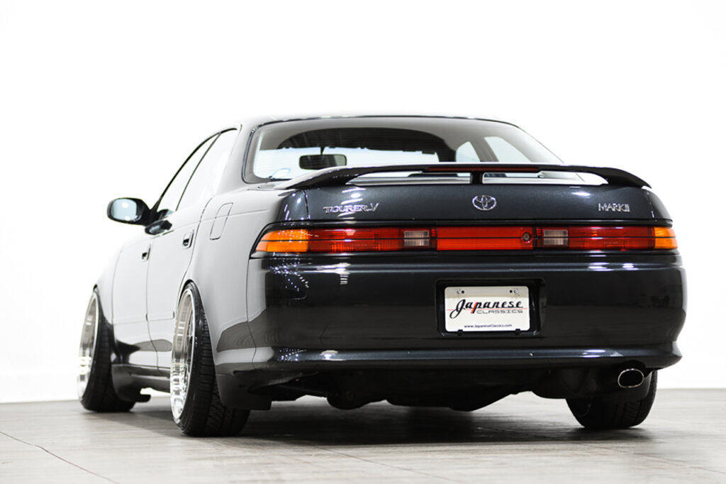 rear side of a black Toyota Mark 2 Tourer V in a showroom floor