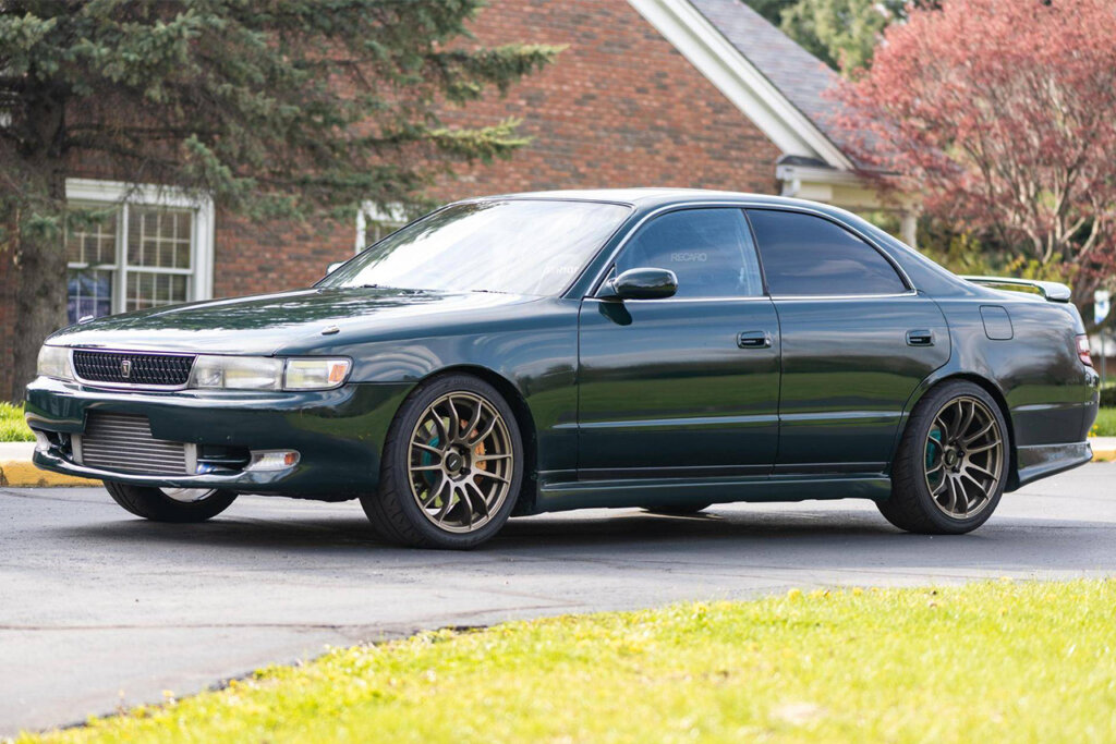 Green Toyota Chaser x90 parked in front of a house