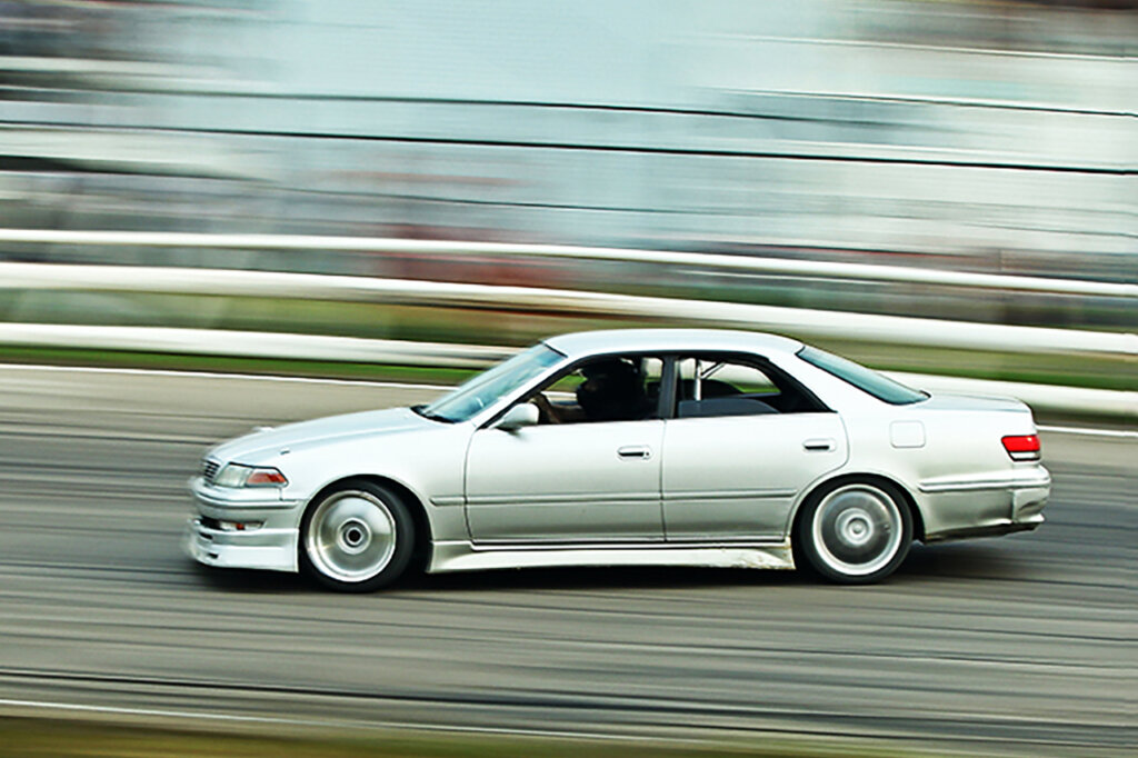 White Toyota Chaser drifting through a turn on a racetrack
