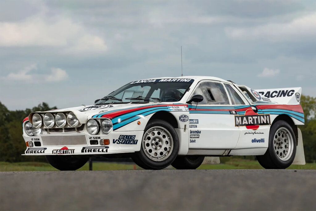 White Martini Lancia 037 parked at an angle with blue sky and clouds