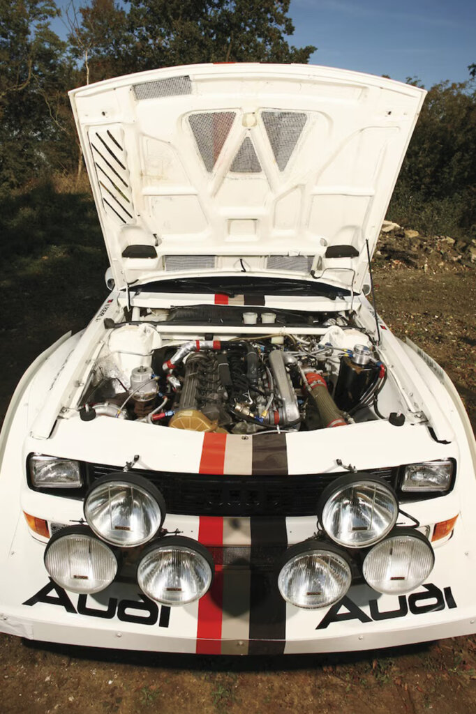 White Audi group B rally race car showing its engine under the hood