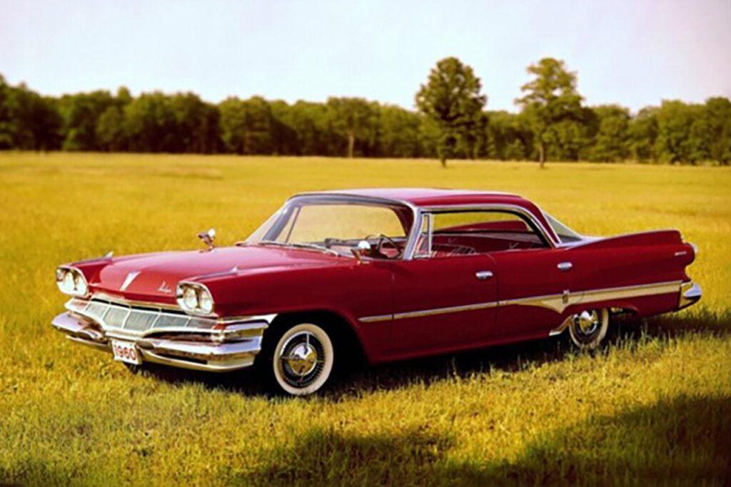 Red Dodge car parked on a field of grass