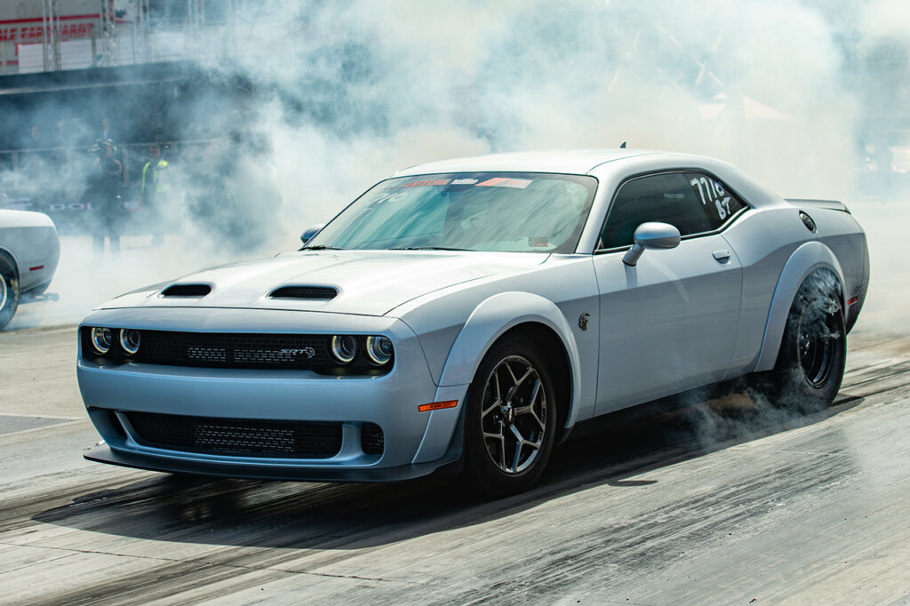 Silver Dodge Demon Challenger doing a burnout on a drag strip