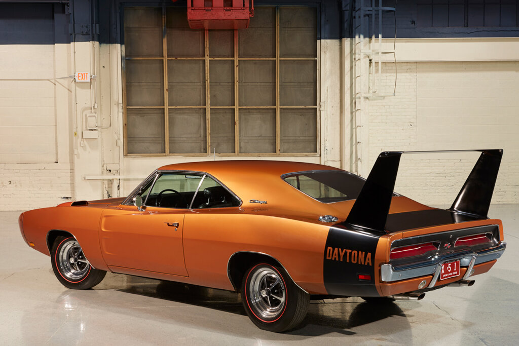 Orange Daytona Charger parked at an angle in a warehouse