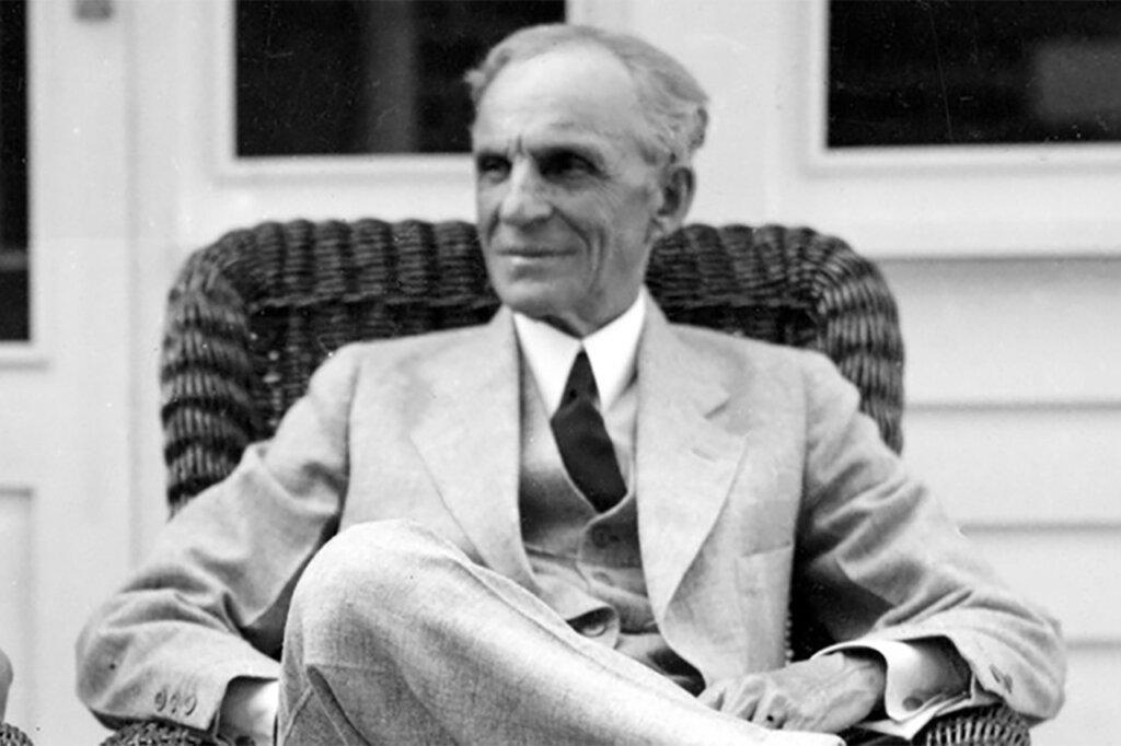 Black and white photo of an older man in a suit sitting down in a chair