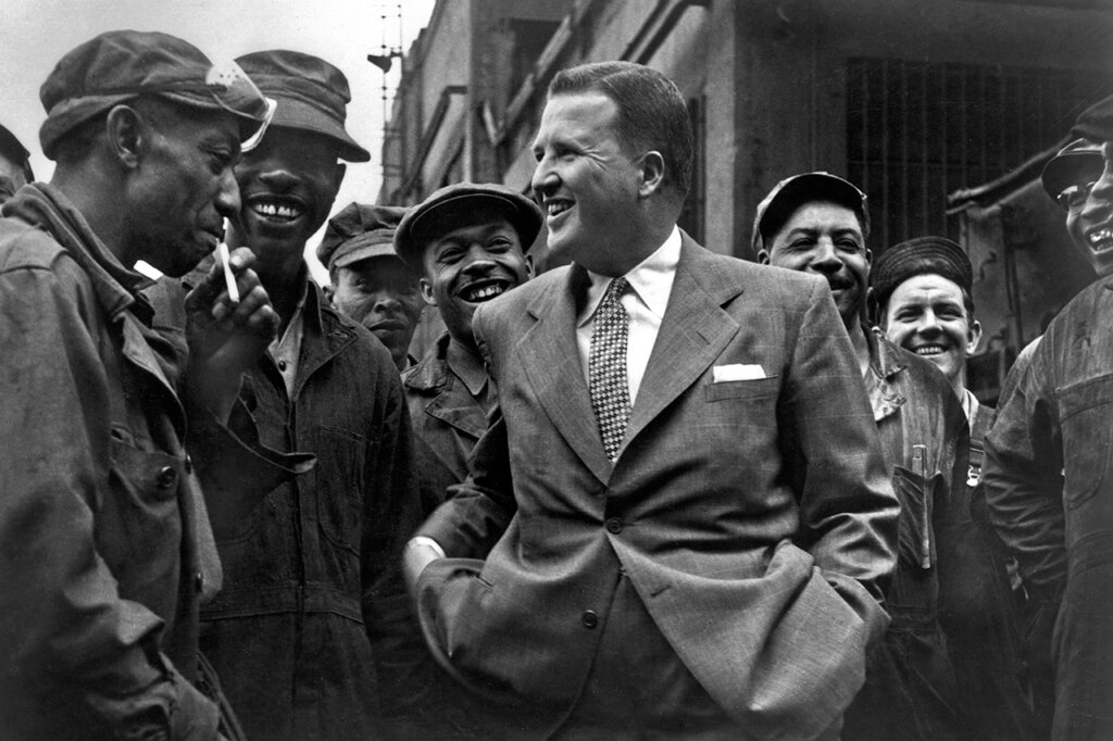 Black and white photo of Henry Ford II with a group of Ford employees