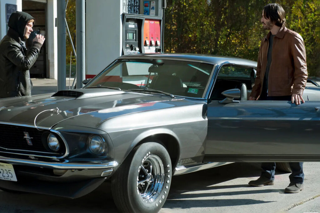 Two men standing next to a Ford Boss 429 Mustang
