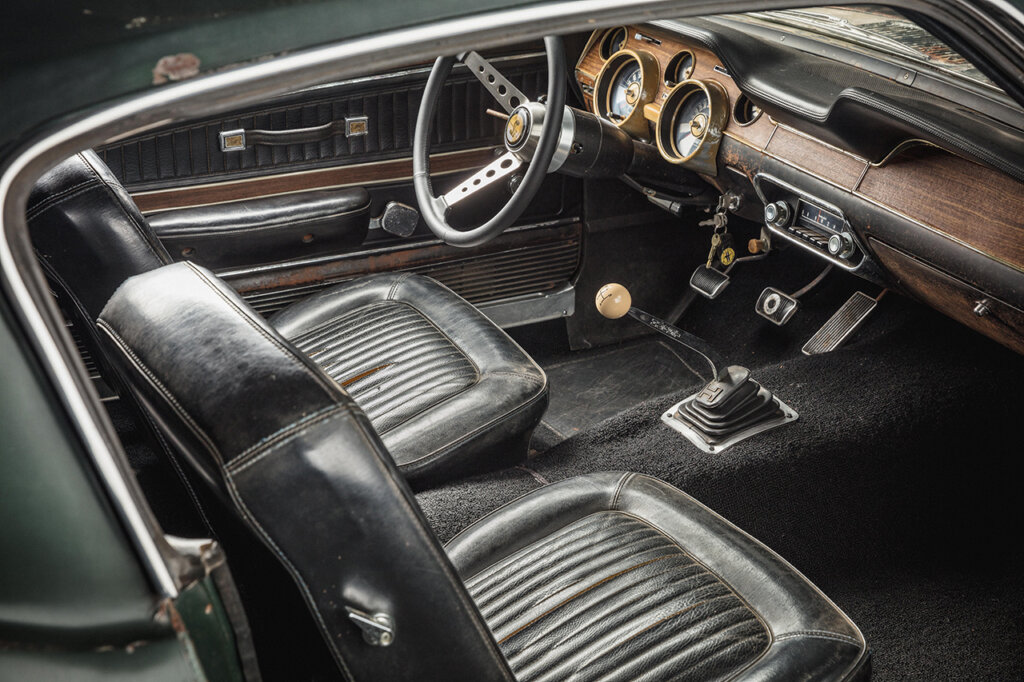 Interior of Ford Bullitt Mustang, two black leather seats and manual shifter