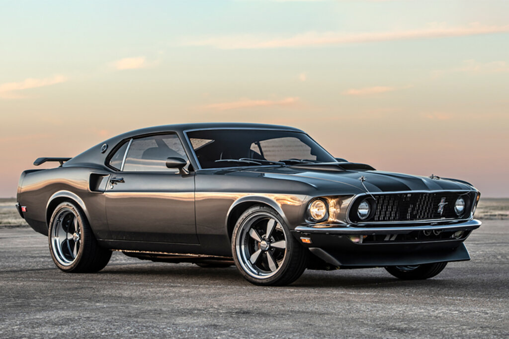 Grey 69' Boss 429 Mustang parked on a road with the cloudy sunset in the background