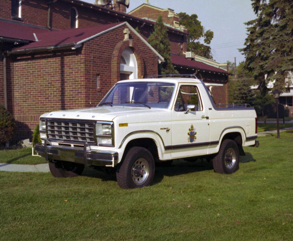 white modified bronco next to a church