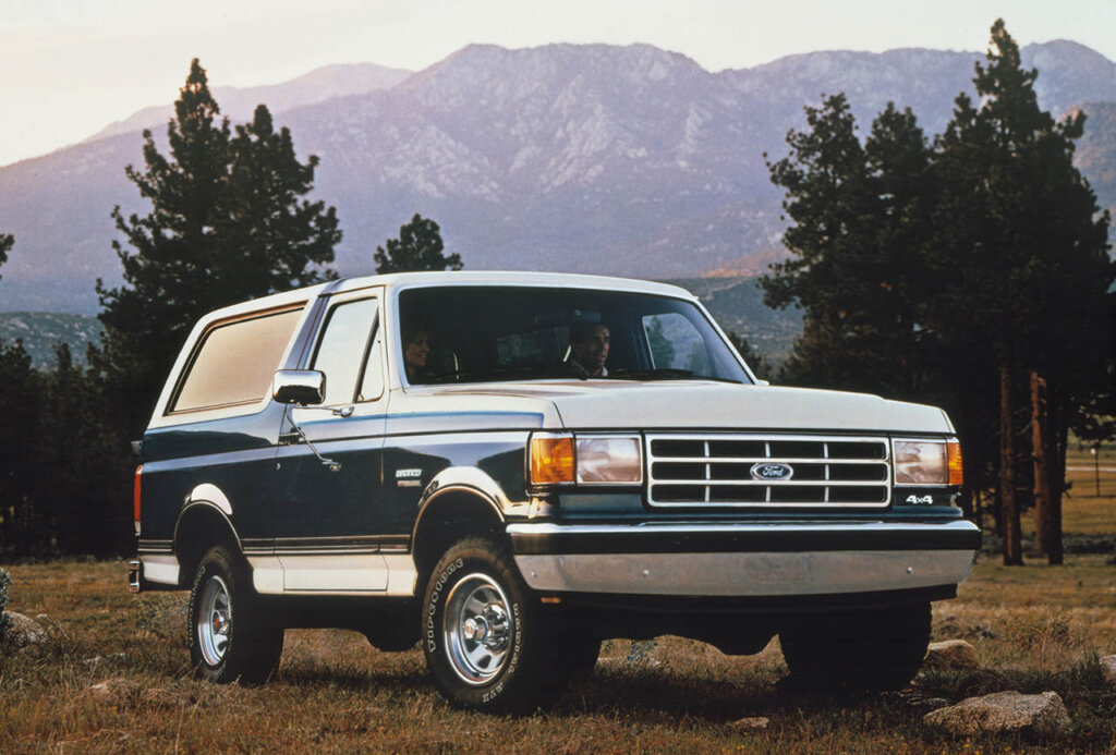 1987 green bronco with white stripes in a forest