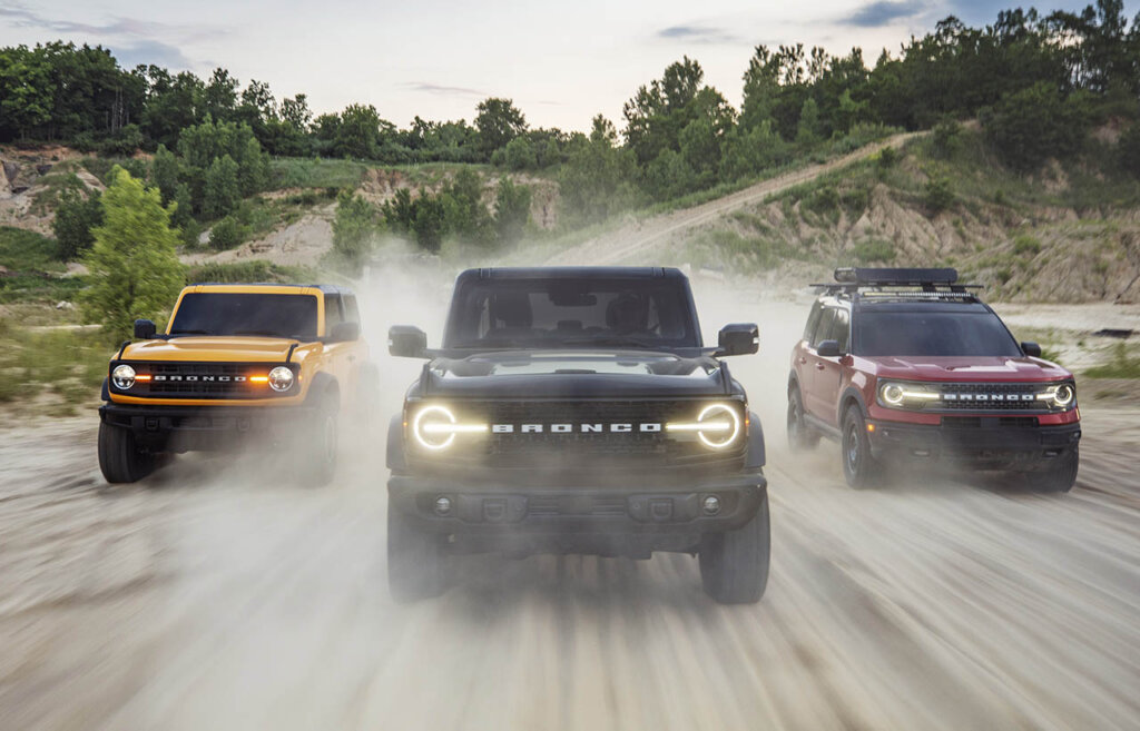 three bronco models racing on a forest road