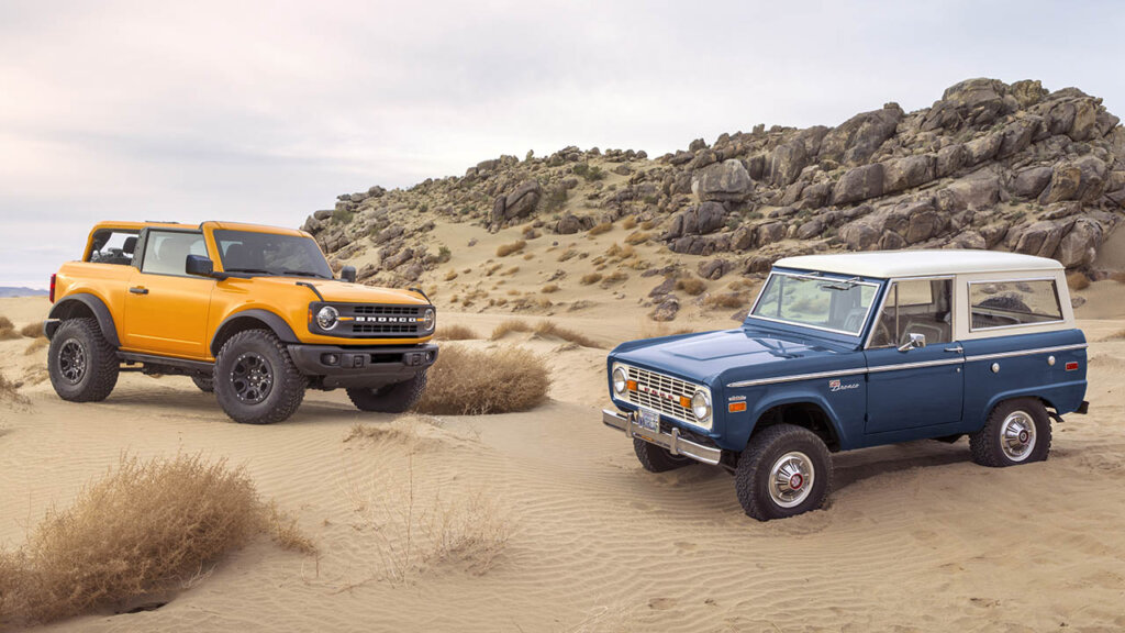 orange bronco and classic blue bronco at a beach