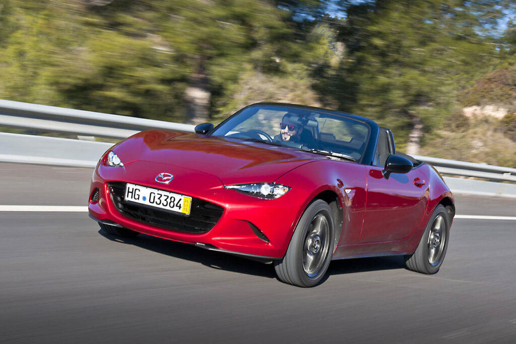 fourth generation mazda mx5 model racing through the countryside