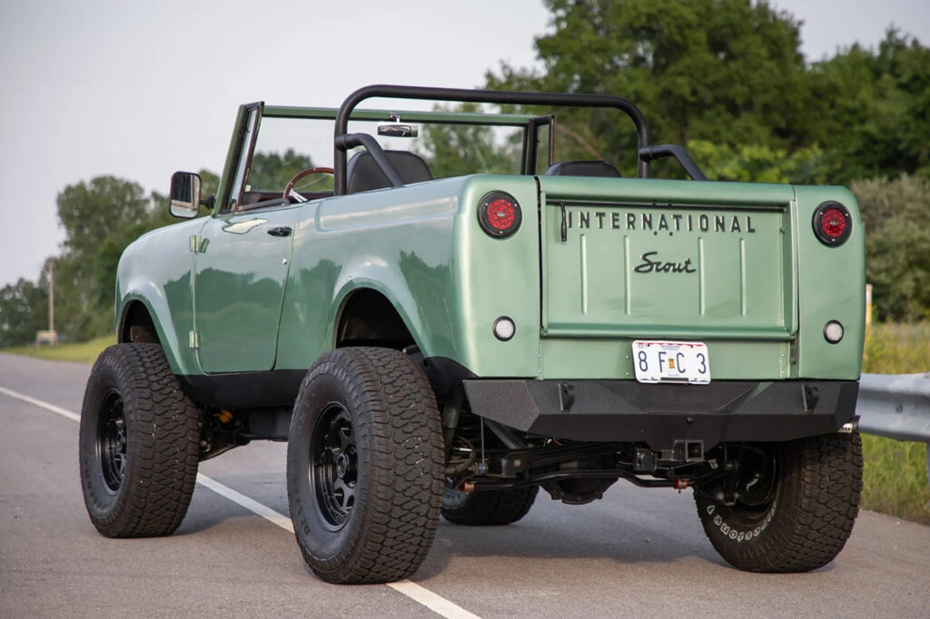 Light green Scout 800 rear parked at an angle with trees behind it
