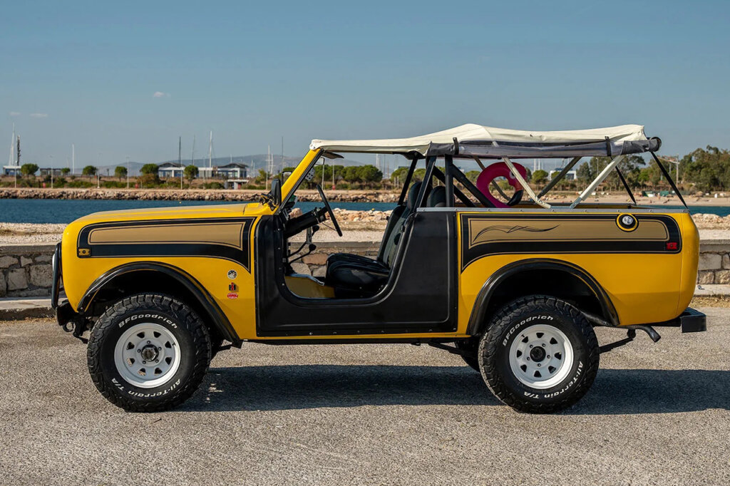 side profile of a yellow Super Scout II with a flamingo in the trunk and white roof