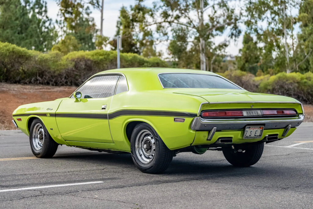 Neon Green Dodge Challenger parked in a parking lot trees in background