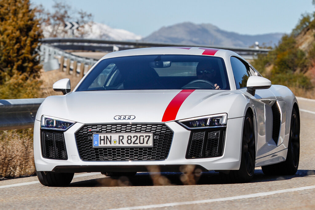 white r8 with red stripe going over hood and roof with a man driving