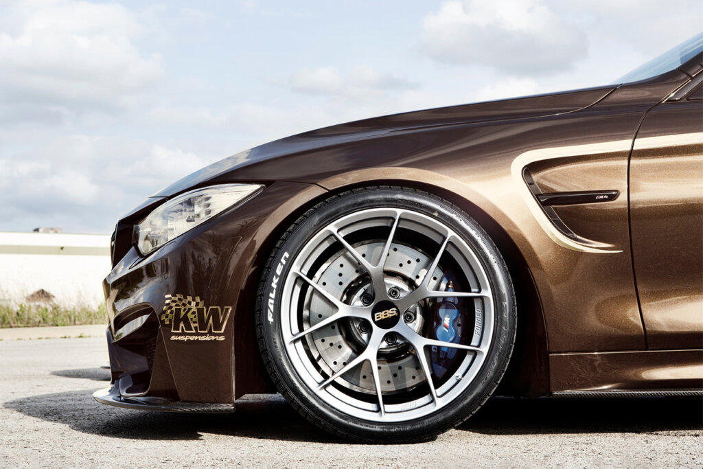 Brown BMW with a BBS wheel with clouds in the sky in background
