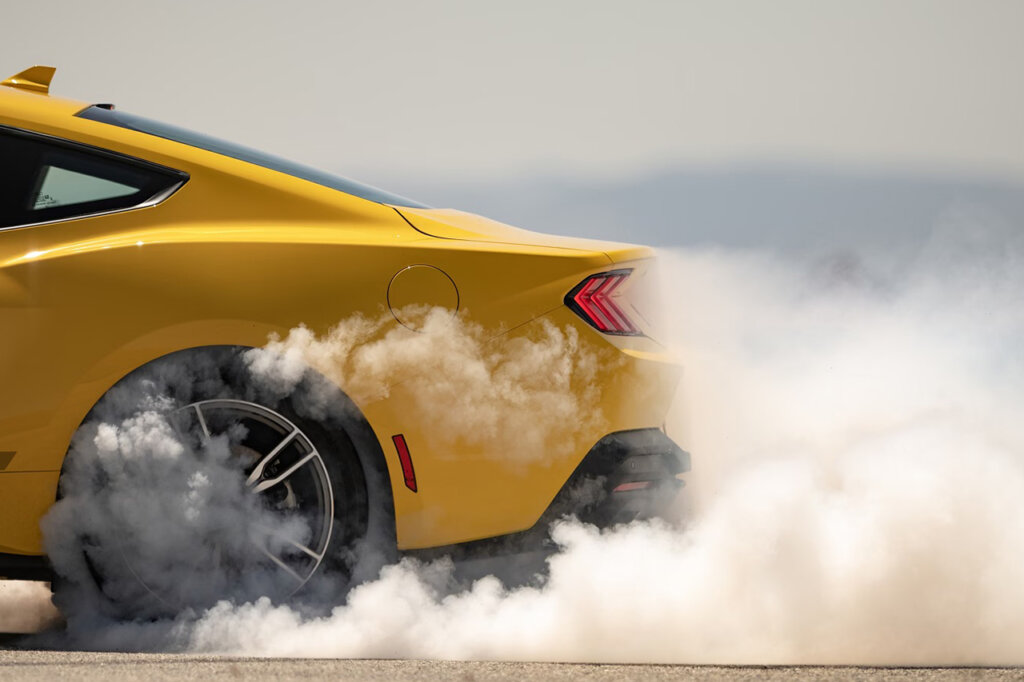 Yellow Mustang GT creating smoke cloud with blurry background