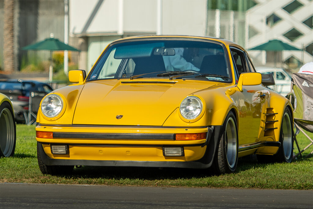 Yellow Porsche 930T 911 parked on the grass