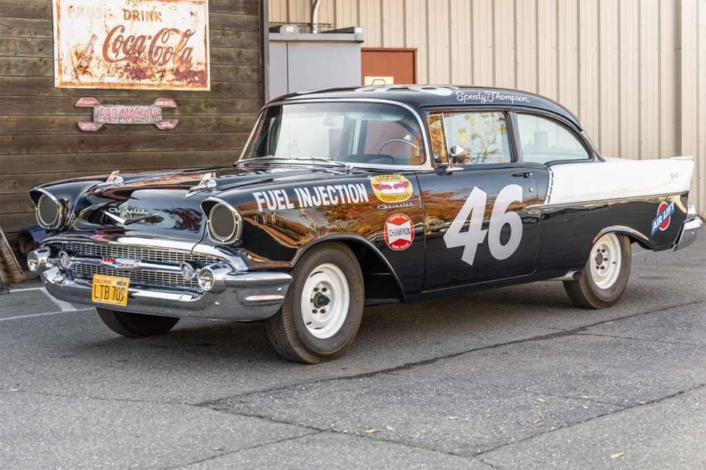 Black and white racing livery number 46 Chevy Nomad displayed in front of a paneled wall