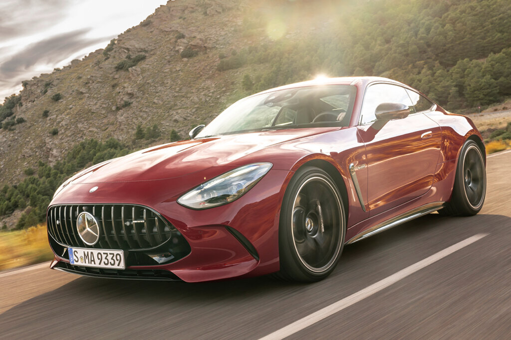 Red Mercedes-Benz driving on freeway with mountains behind it