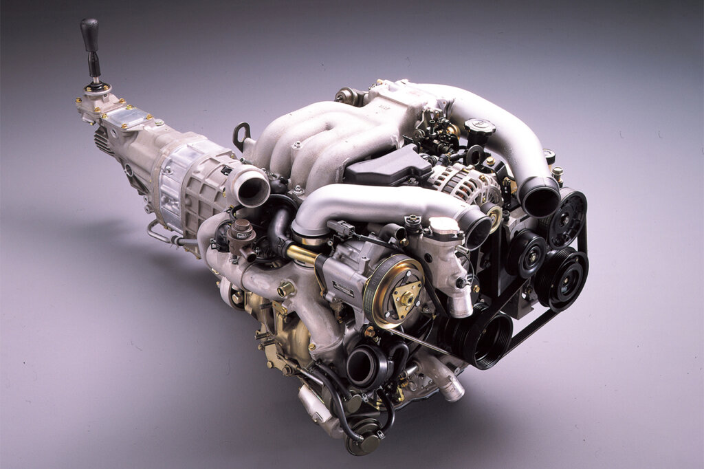13B rotary engine attached to transmission on grey background