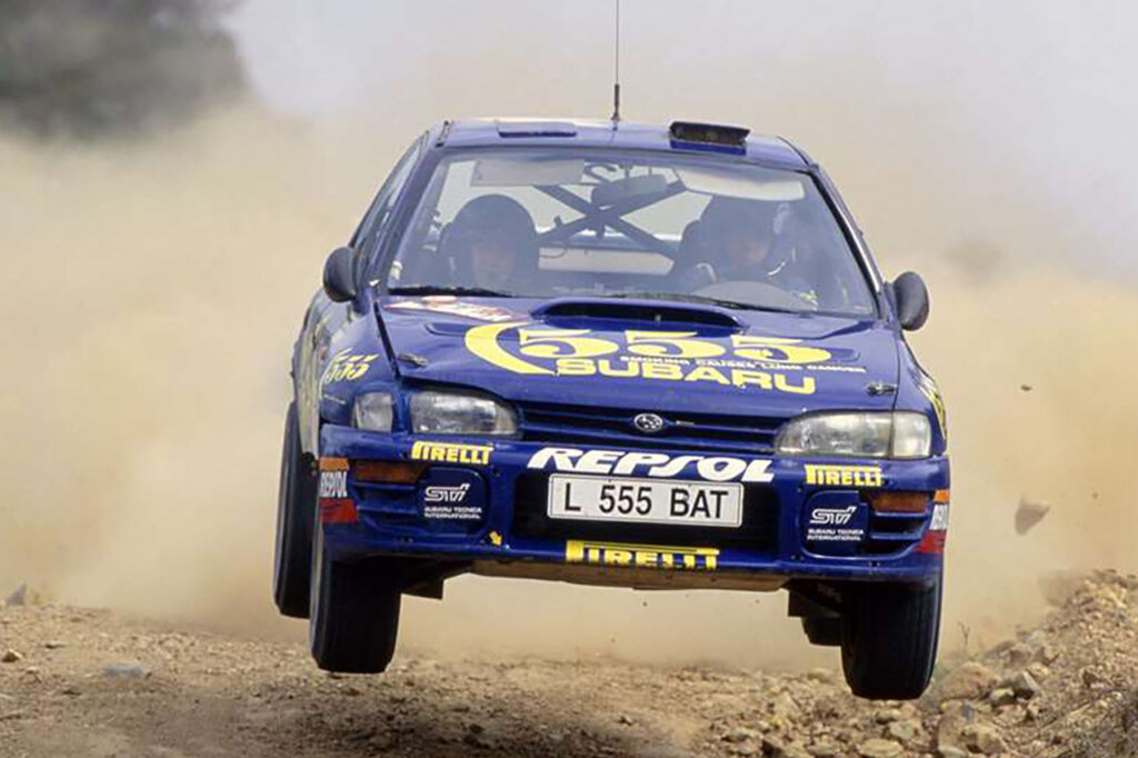 Blue Impreza STI in the air leaving a cloud of smoke behind