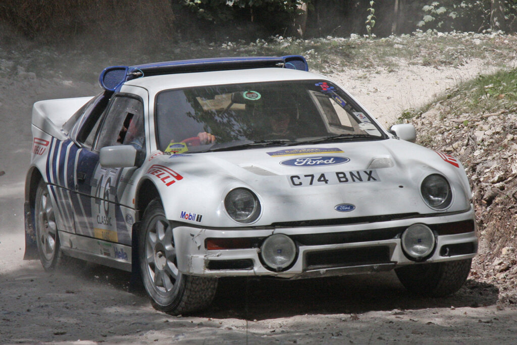 White and blue Ford Escort RS200 with a man behind the wheel