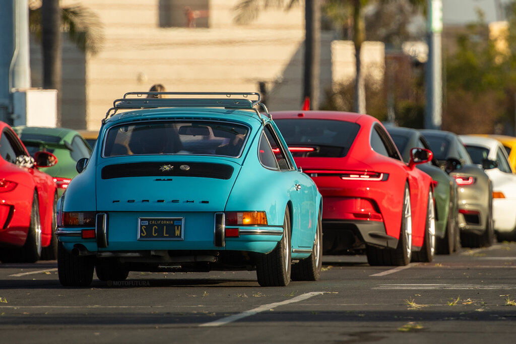blue and red porsche vehicles in a line behind one another