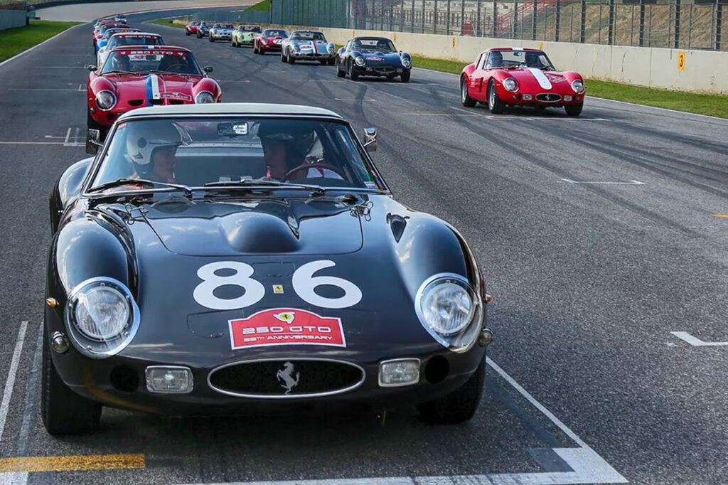 Black Ferrari with number 86 on the hood of the car with several cars behind them on a race car