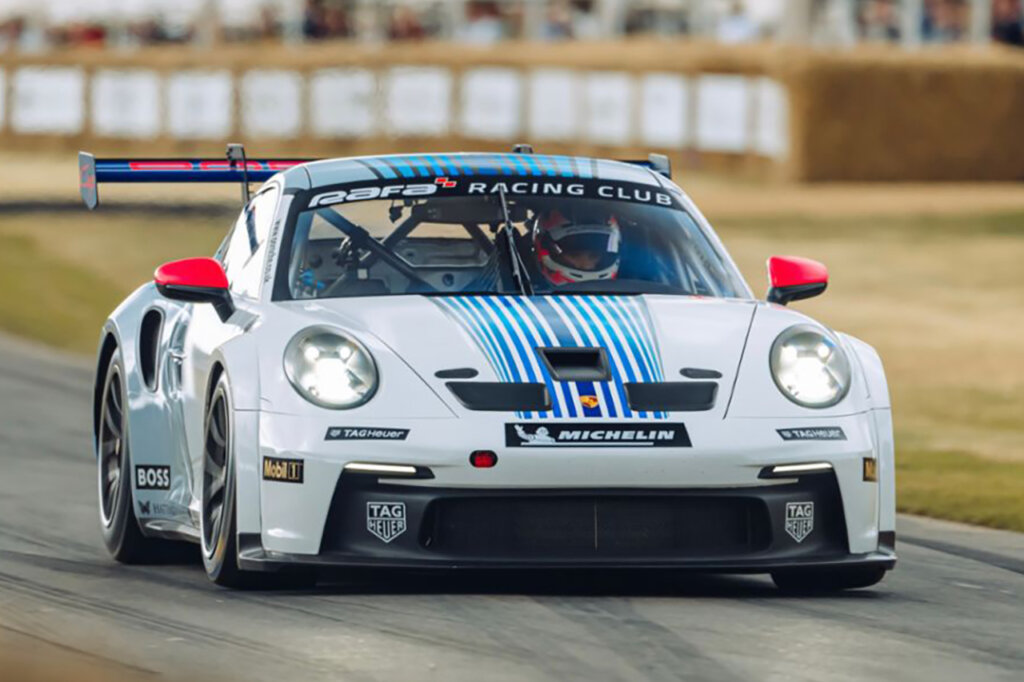 White Porsche 911 992 GT3 Cup race car driven by a man on a racetrack
