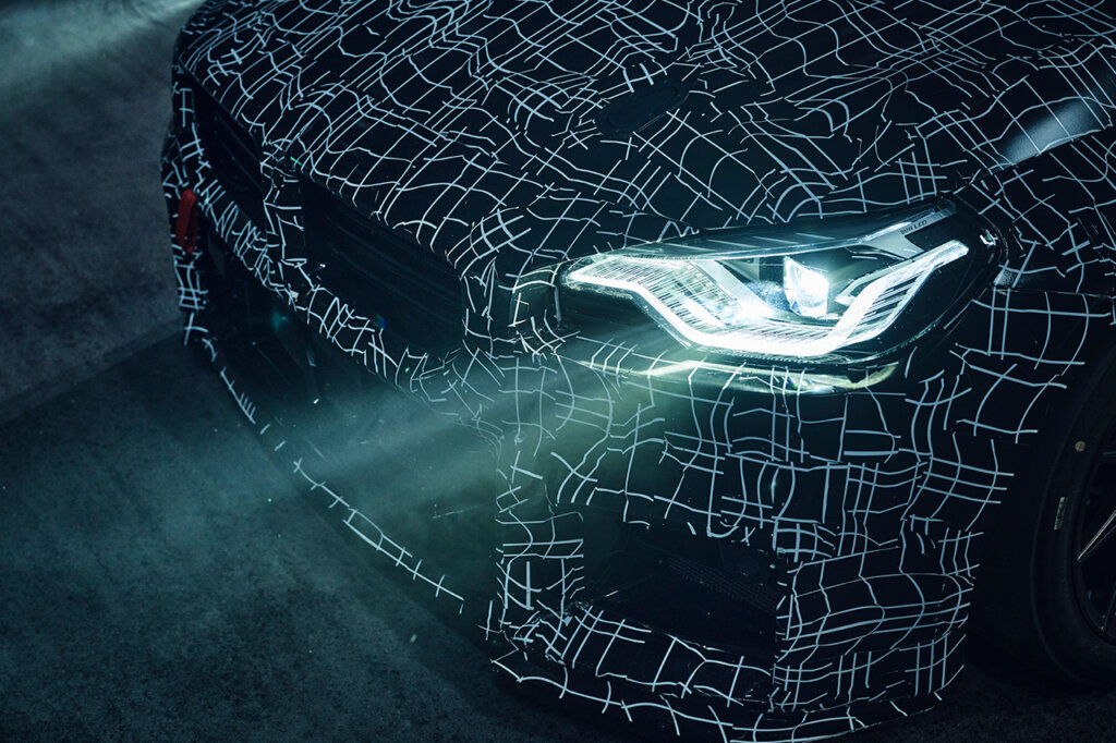 Detail shot of a BMW front end and an LED headlight with black graphics on the front hood and bumper