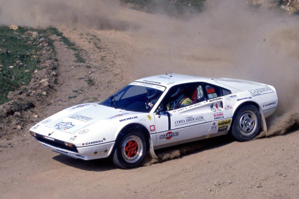 White Ferrari 308 going through a dirt race track leaving dust cloud behind it