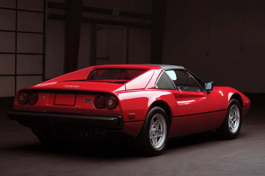 Red Ferrari 308 GTBi parked in a dark room