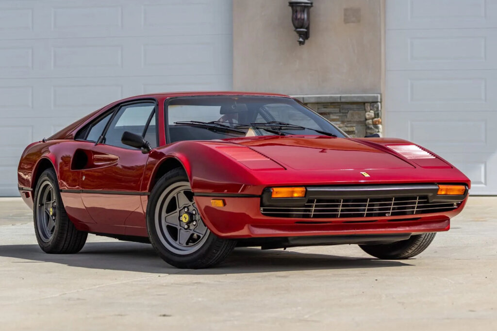 Red Ferrari car parked in front of garage doors