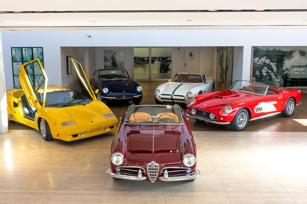 Various classic cars next to one another inside of a garage
