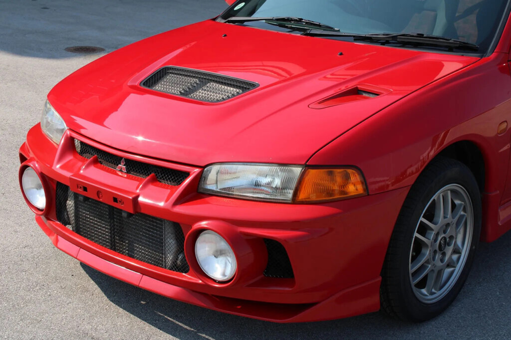 Red Evo IV with a vent on the hood and circular fog lights and vents on the front bumper
