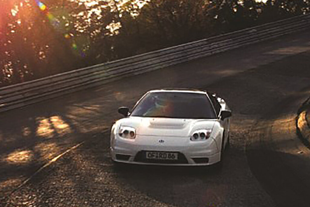 White Honda NSX-R driving on a racetrack with the sunsetting in the background