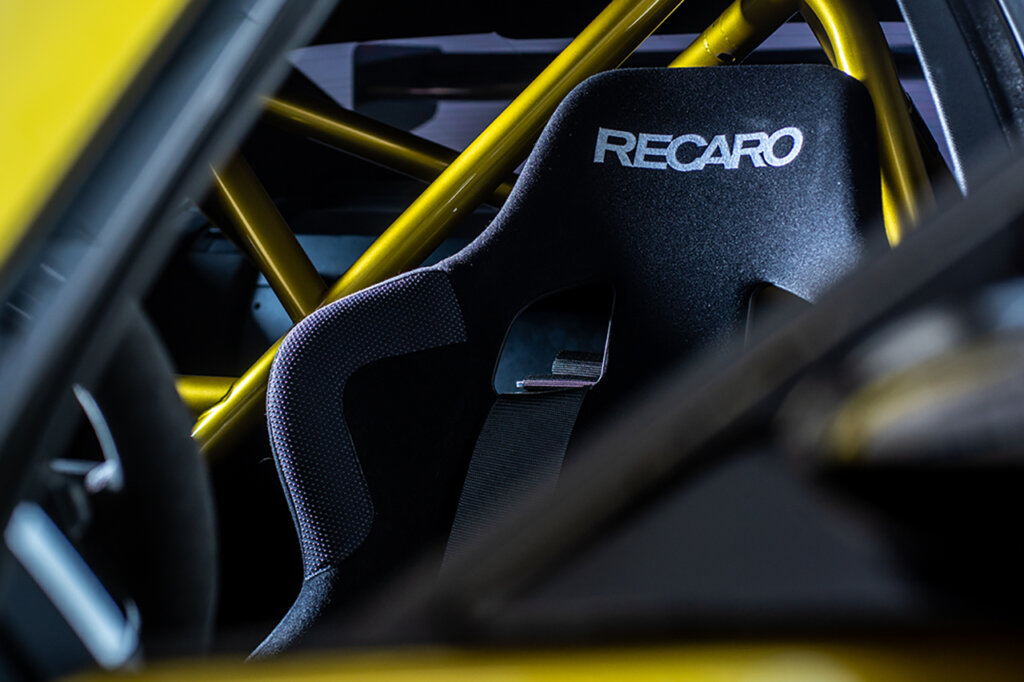 Recaro racing seat in a yellow car with yellow tubing behind it