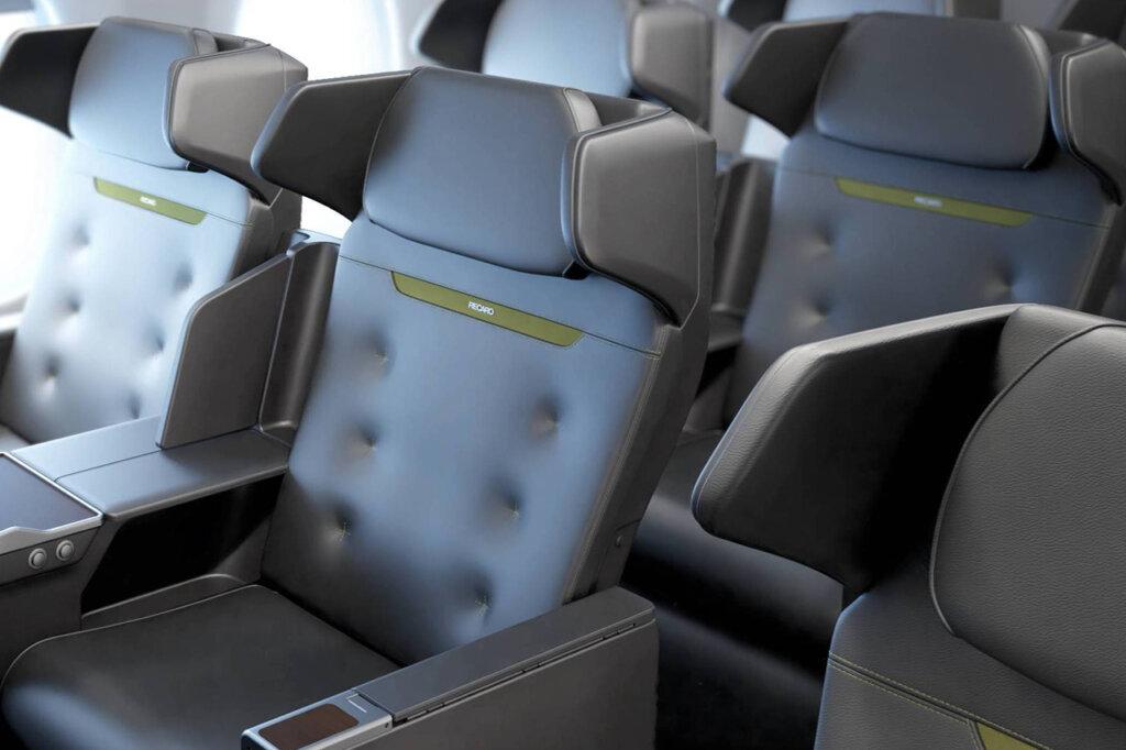 black leather aviation seats with Recaro branding on the seat next to several other identical seats next to it