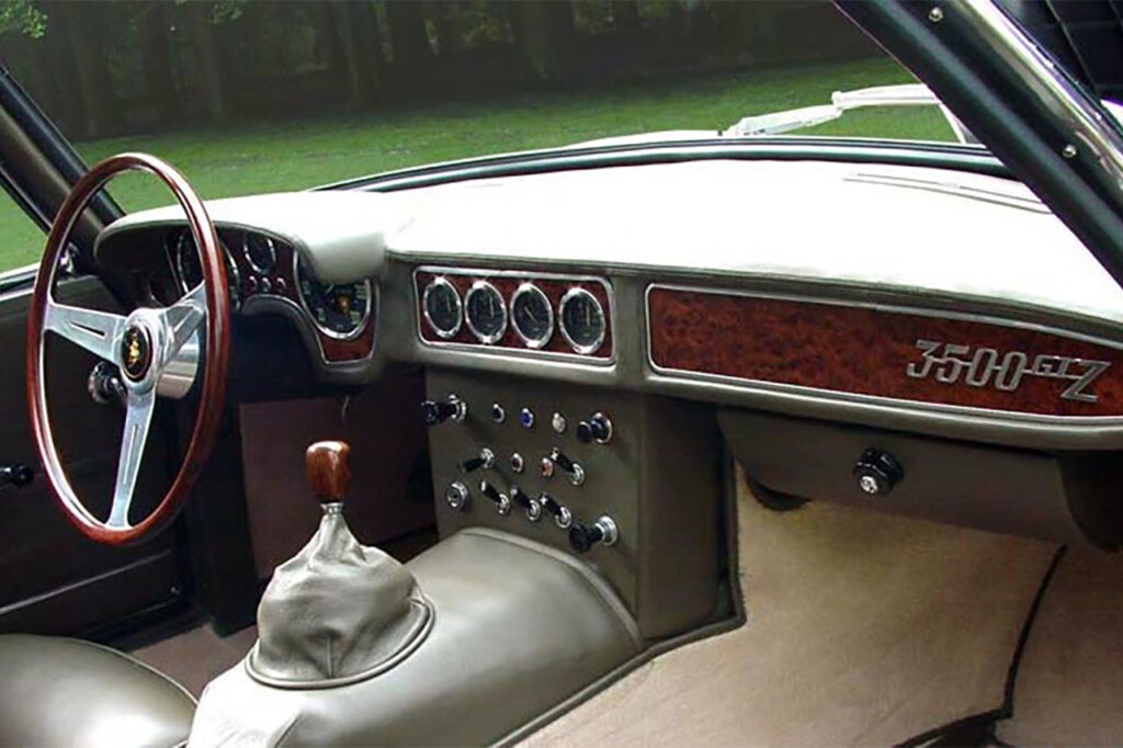 Wood grain dashboard with circular gauges in the center above the manual gear selector