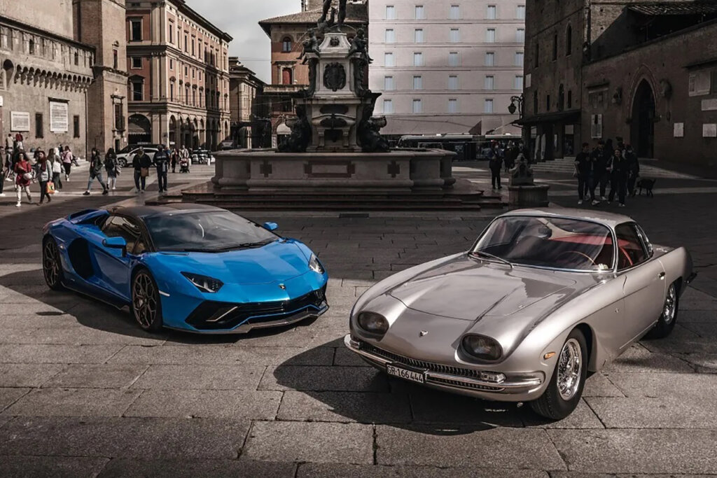 Two Lamborghini cars parked next to one another one blue one silver in a city plaza