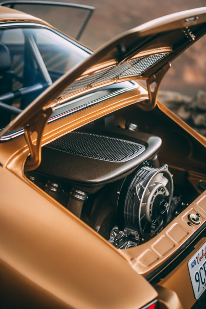 Rear flat six engine with modified valve cover inside of a gold car