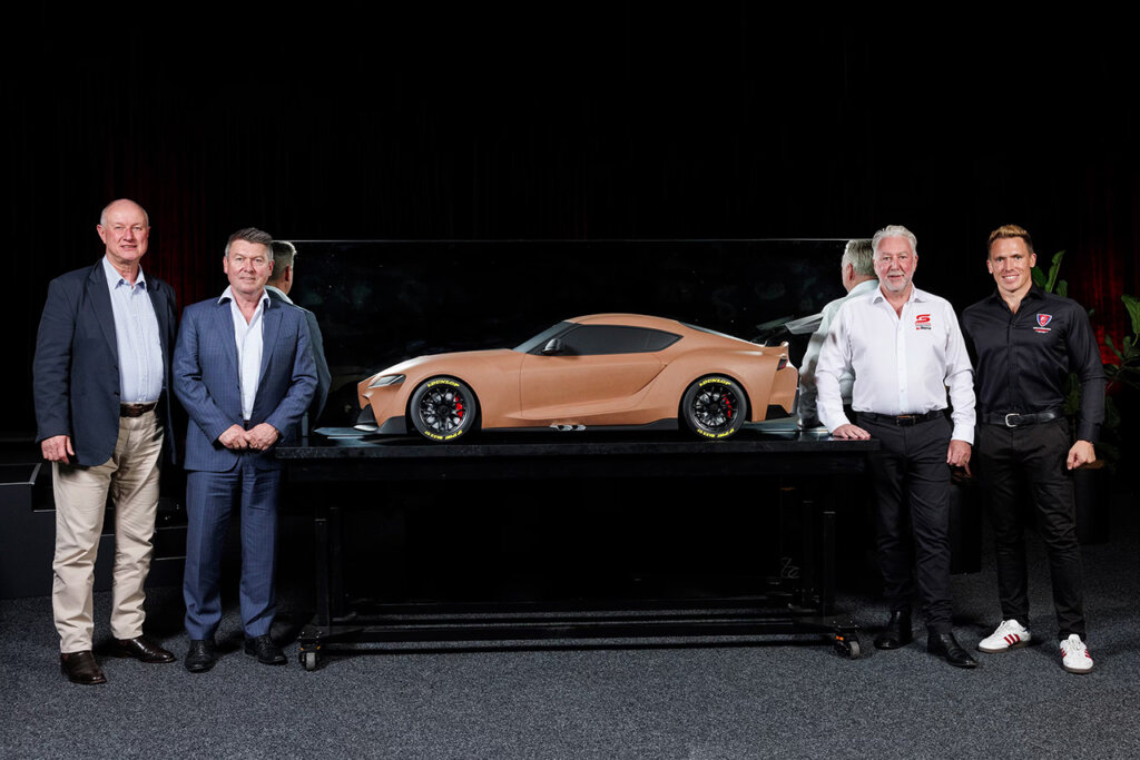 Clay Toyota Supra model with 4 men in suits standing next to it