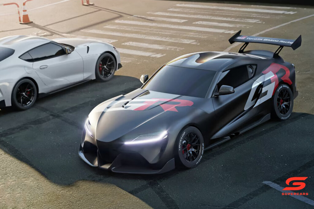 Two cars one white one dark grey parked next to one another. The dark grey Supra has a red and white decal on the rear
