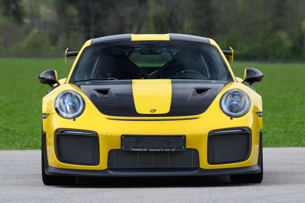 Yellow and black Porsche 991 991 GT2 RS parked with green grass behind it