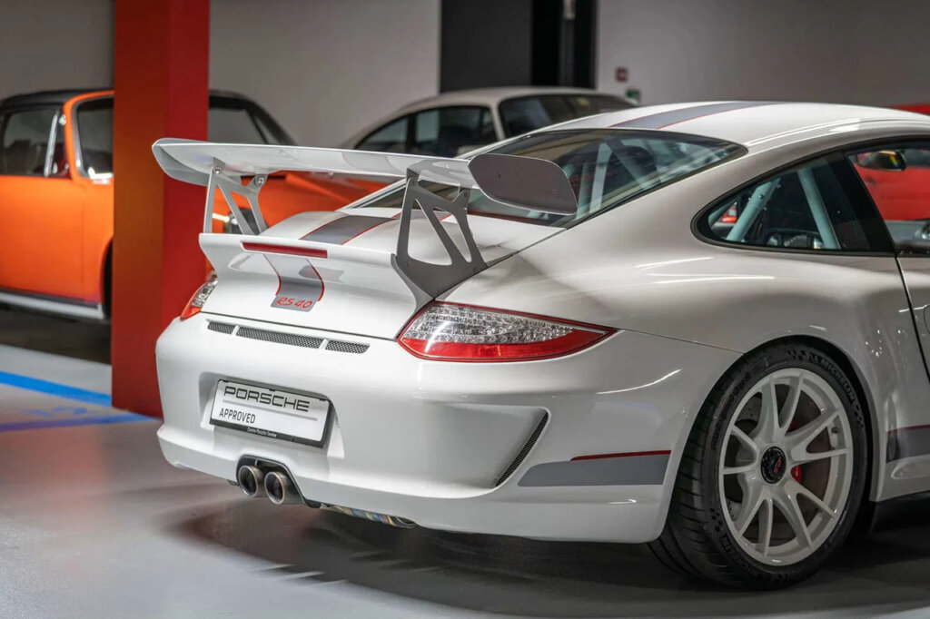 White with silver trim Porsche 911 997 GT3 RS 4.0 rear end inside of a garage with other cars in the background