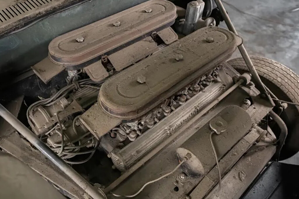 old Lamborghini V12 engine covered in dust and dirt setup horizontally to the rear end of the car